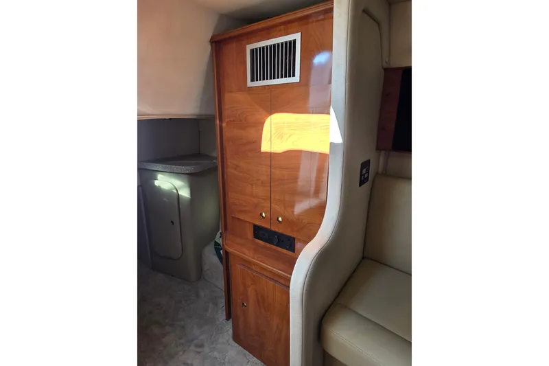 Slide: The Image of 2005 Rinker 300 Express Cruiser interior with wooden cabinetry and seating area. - 24