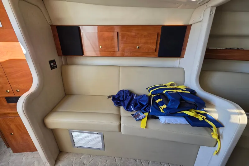 Slide: The Image of Interior of 2005 Rinker 300 Express Cruiser with beige seating and life jackets. - 25