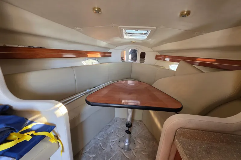 Slide: The Image of 2005 Rinker 300 Express Cruiser cabin interior with seating and table. - 27