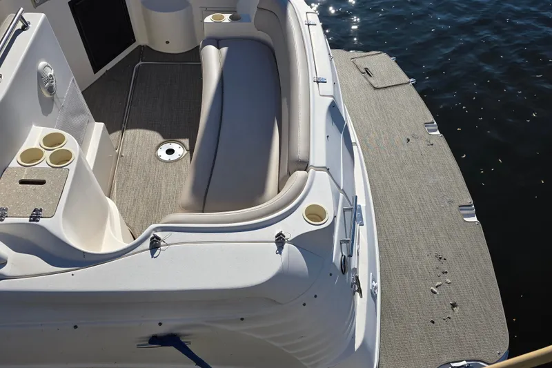Slide: The Image of 2005 Rinker 300 Express Cruiser boat interior with seating and cup holders by the water. - 4