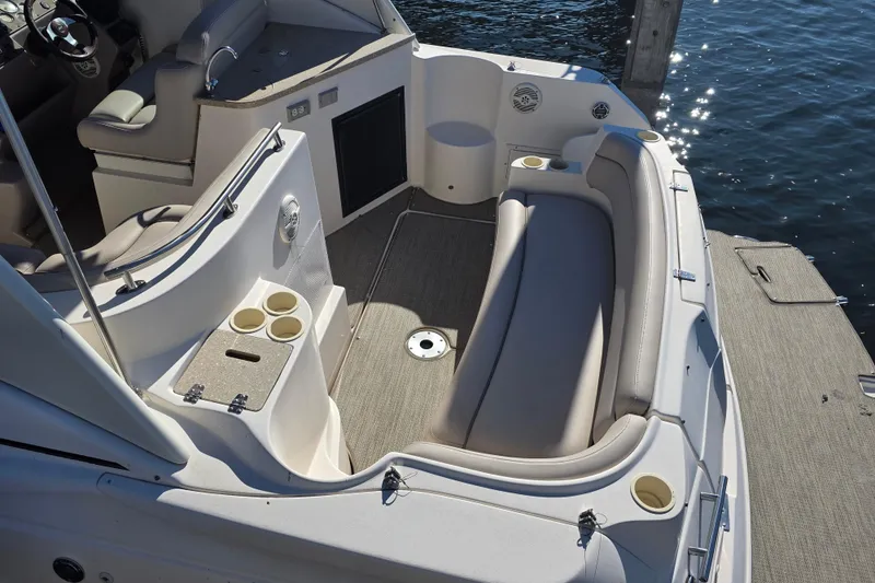 Slide: The Image of 2005 Rinker 300 Express Cruiser interior with seating and cup holders by the water. - 5
