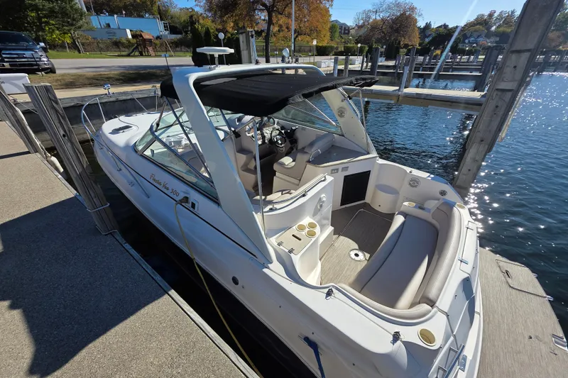 Slide: The Image of 2005 Rinker 300 Express Cruiser docked at marina, featuring spacious seating and sleek design. - 6