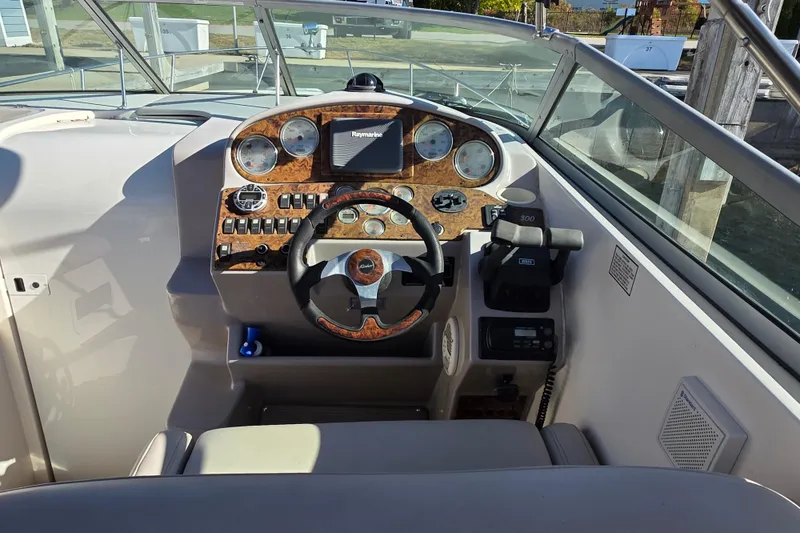 Slide: The Image of 2005 Rinker 300 Express Cruiser helm with woodgrain dashboard and steering wheel. - 9