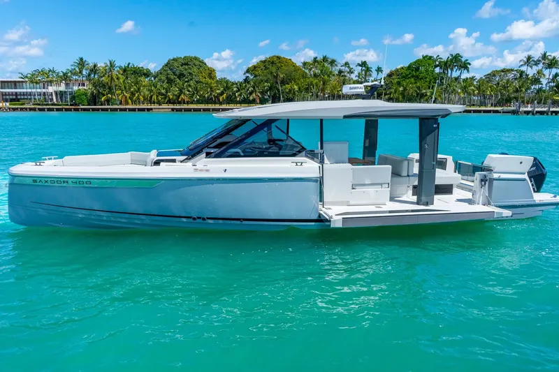Slide: The Image of 2025 Saxdor 400 GTO luxury boat on turquoise water, clear sky background. - 0