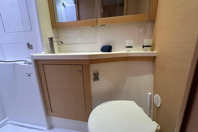 Slide: The Image of Bathroom interior of 2014 Lagoon 450 F yacht, featuring sink, mirror, and toilet. - 16