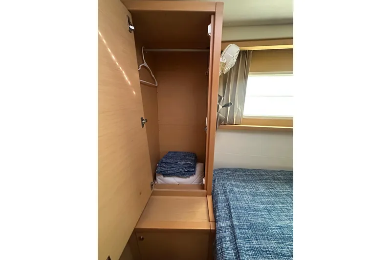 Slide: The Image of Interior of 2014 Lagoon 450 F yacht showing a cozy cabin with wardrobe and bed. - 19