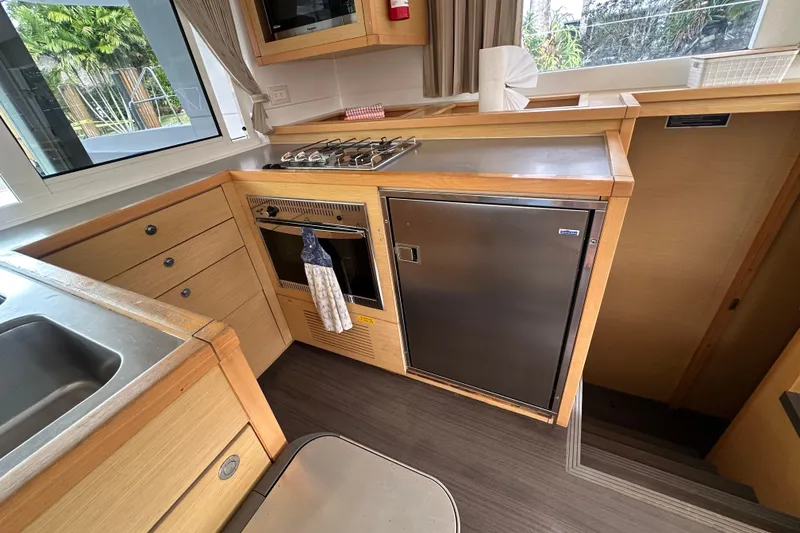 Slide: The Image of Interior of 2014 Lagoon 450 F yacht kitchen with stove, oven, and stainless steel fridge. - 3