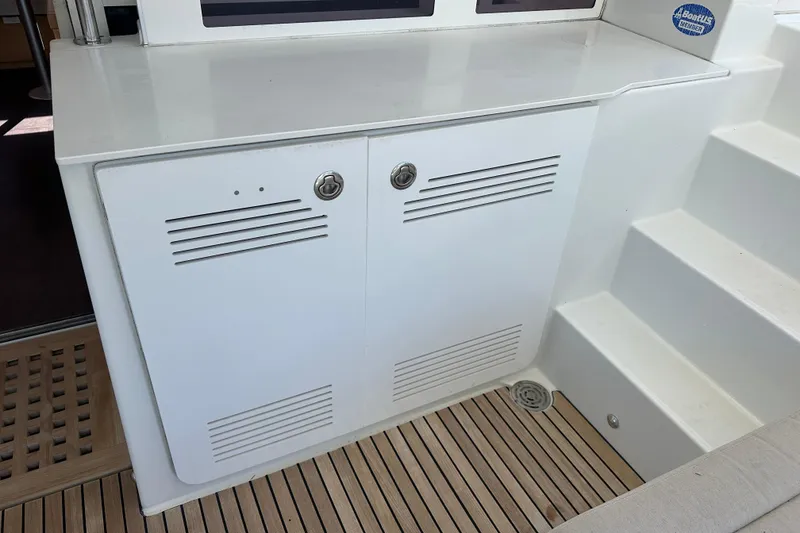 Slide: The Image of White storage cabinet on Lagoon 450 F yacht, 2014 model, with teak flooring and steps. - 59