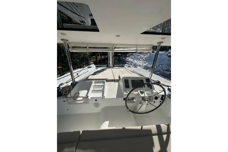 Slide: The Image of Lagoon 450 F 2014 catamaran helm with steering wheel, navigation controls, and sunlit deck. - 66