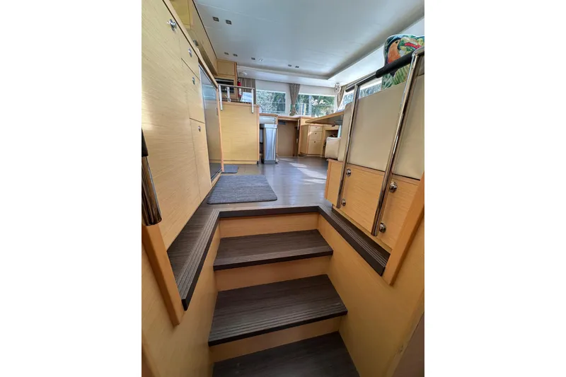 Slide: The Image of Interior of 2014 Lagoon 450 F yacht, featuring wooden stairs and modern design. - 7