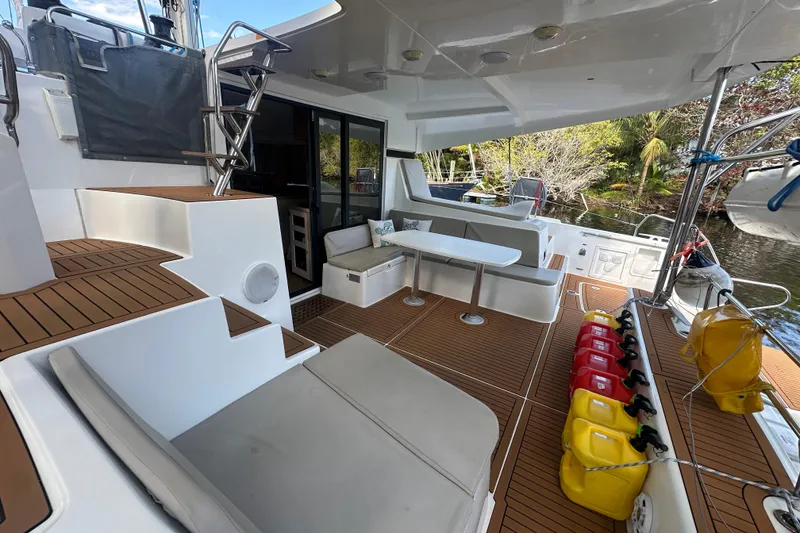 Slide: The Image of 2019 Lagoon 42 catamaran deck with seating, table, and fuel containers. - 10
