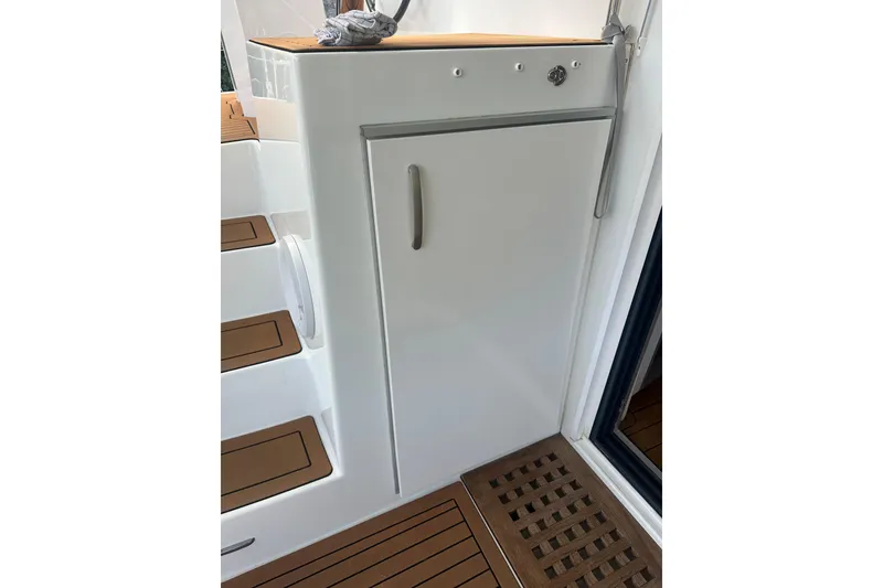 Slide: The Image of 2019 Lagoon 42 yacht interior with sleek white cabinetry and wooden flooring. - 14