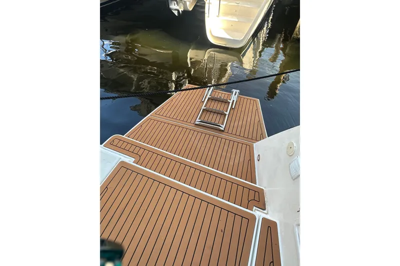 Slide: The Image of Teak deck of 2019 Lagoon 42 catamaran with swim ladder, docked by water. - 27