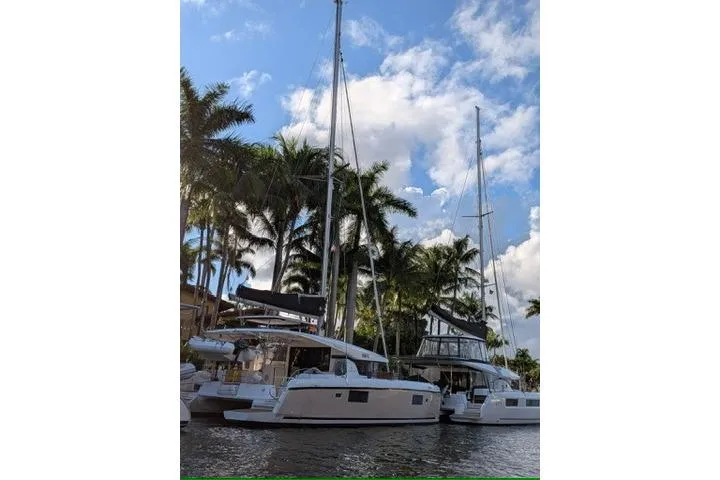 Slide: The Image of 2019 Lagoon 42 catamarans docked by palm trees under a blue sky. - 3