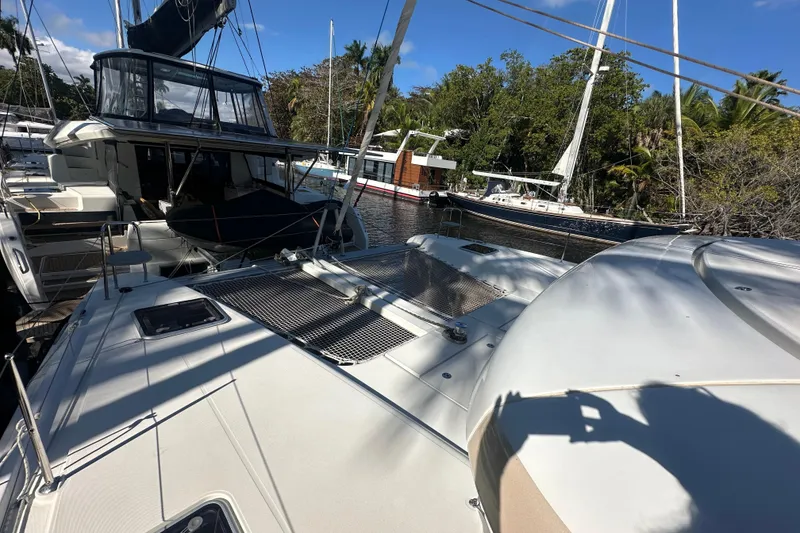 Slide: The Image of 2019 Lagoon 42 catamaran docked, surrounded by lush greenery and other boats. - 31