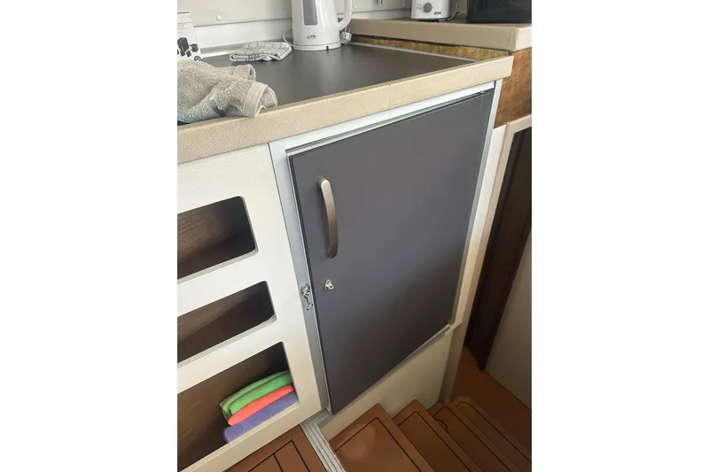 Slide: The Image of Interior of 2019 Lagoon 42 yacht kitchen with countertop and storage shelves. - 37
