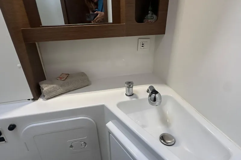 Slide: The Image of Bathroom sink area in 2019 Lagoon 42 yacht with towel and mirror. - 43