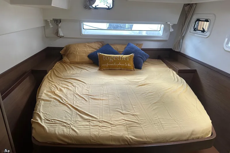 Slide: The Image of Cozy cabin bedroom in 2019 Lagoon 42 catamaran with yellow bedding and decorative pillows. - 44