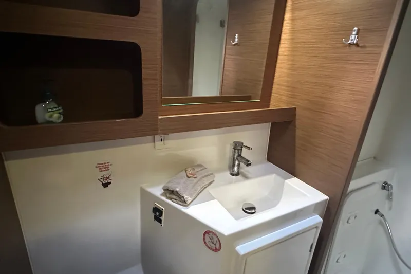 Slide: The Image of Modern bathroom in 2019 Lagoon 42 yacht with sink, mirror, and wooden cabinetry. - 48