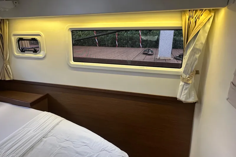 Slide: The Image of Interior cabin view of 2019 Lagoon 42 catamaran with window and curtains. - 53
