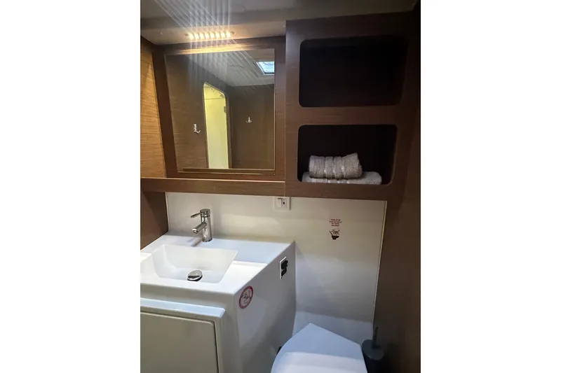 Slide: The Image of Bathroom interior of 2019 Lagoon 42 yacht with sink, mirror, and shelves. - 55