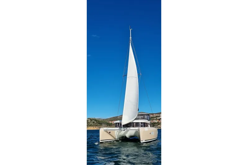 Slide: The Image of 2019 Lagoon 42 catamaran sailing on clear blue waters under a bright sky. - 6