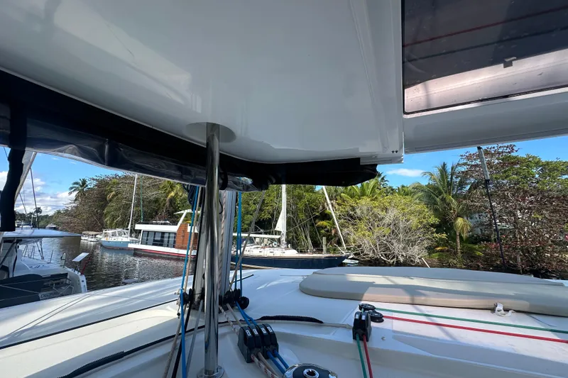 Slide: The Image of 2019 Lagoon 42 catamaran docked, surrounded by lush greenery and other boats. - 61