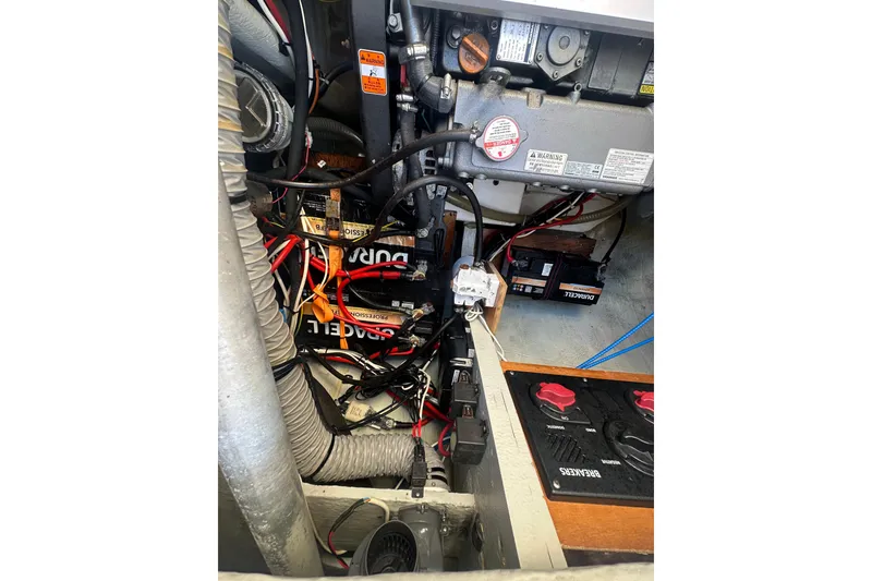 Slide: The Image of Engine compartment of a 2019 Lagoon 42 catamaran with visible wiring and batteries. - 65