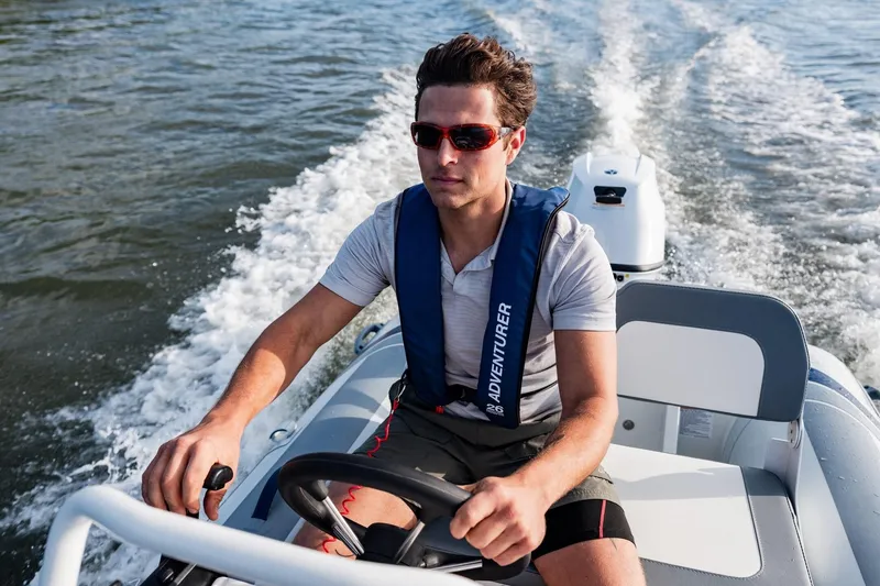 Slide: The Image of Man driving 2026 Highfield Classic 380 boat on water. - 2