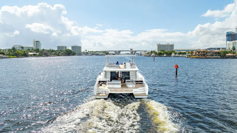 Slide: The Image of 2024 Leopard 53 Powercat cruising on a sunny day in a scenic waterway. - 15