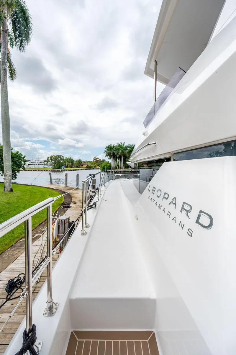 Slide: The Image of 2024 Leopard 53 Powercat yacht docked by lush greenery. - 17