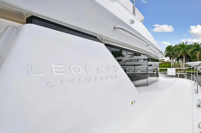 Slide: The Image of 2024 Leopard 53 Powercat yacht, sleek design, luxury catamaran, sunny day, palm trees in background. - 18