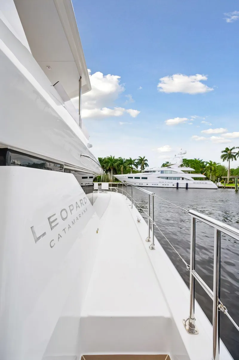Slide: The Image of 2024 Leopard 53 Powercat yacht docked by a serene waterfront. - 19