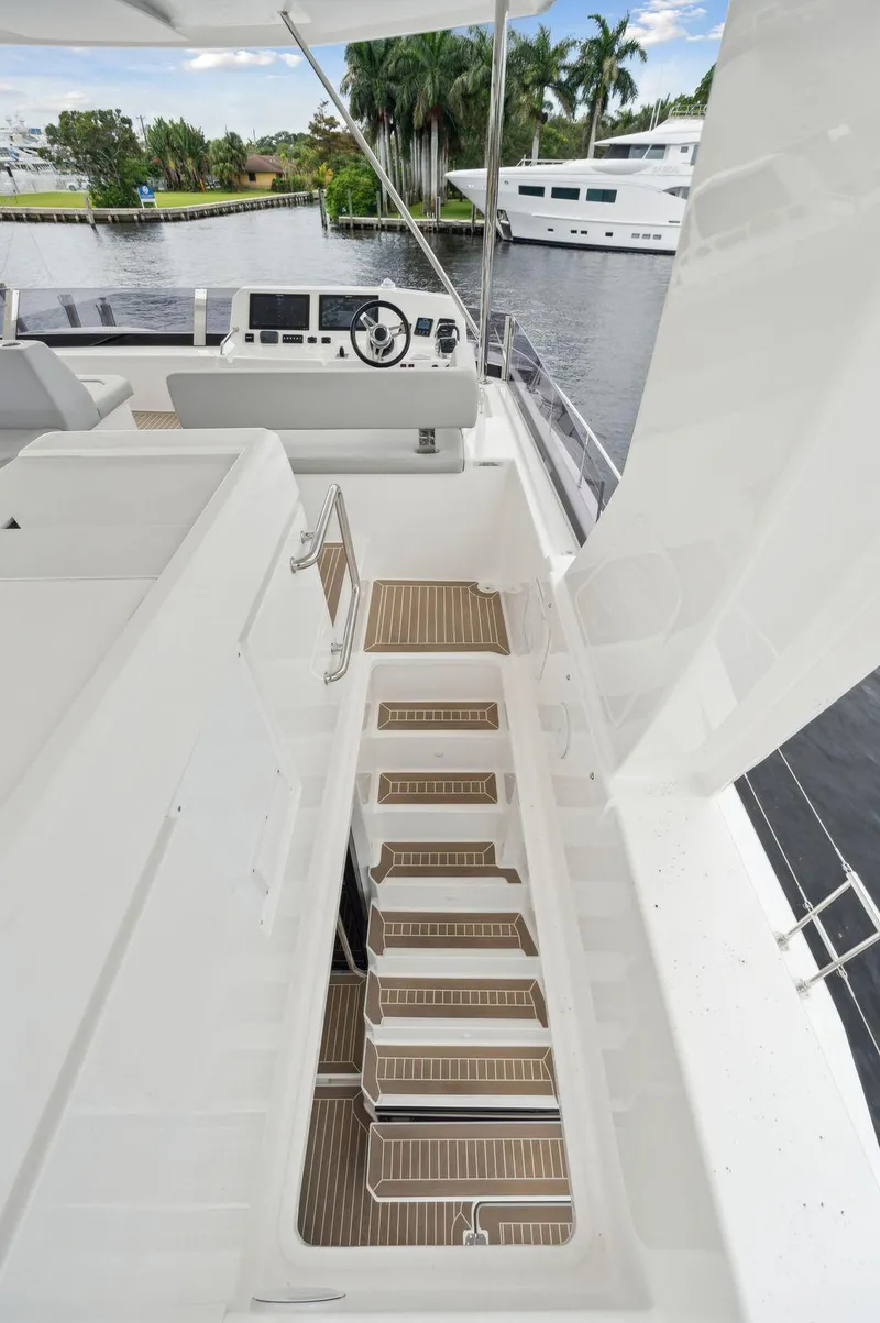 Slide: The Image of 2024 Leopard 53 Powercat yacht with modern deck and helm, docked near lush greenery. - 20