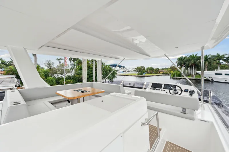 Slide: The Image of 2024 Leopard 53 Powercat yacht interior with helm, seating, and table, overlooking marina. - 21