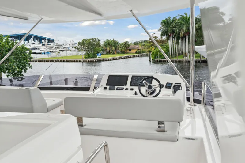 Slide: The Image of 2024 Leopard 53 Powercat yacht helm with waterfront view and lush greenery. - 22