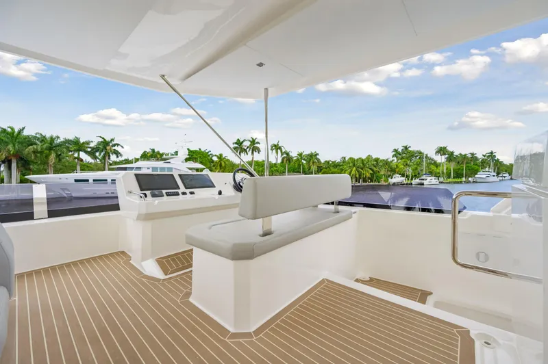 Slide: The Image of 2024 Leopard 53 Powercat yacht deck with modern helm and tropical backdrop. - 24
