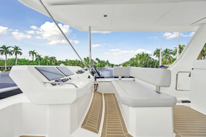 Slide: The Image of 2024 Leopard 53 Powercat helm with modern controls and seating, surrounded by tropical scenery. - 25