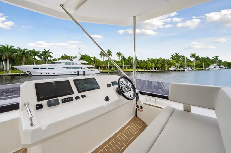 Slide: The Image of 2024 Leopard 53 Powercat helm with waterfront view and palm trees. - 26