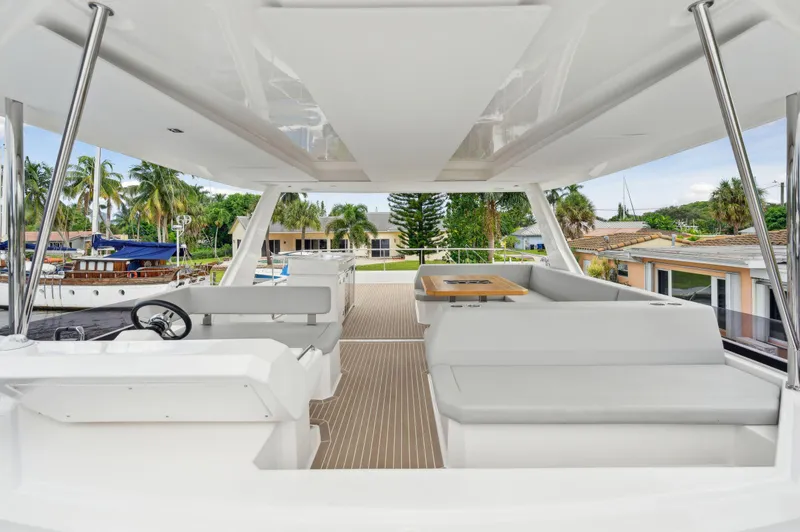 Slide: The Image of 2024 Leopard 53 Powercat interior with modern seating and steering, docked near palm trees. - 29