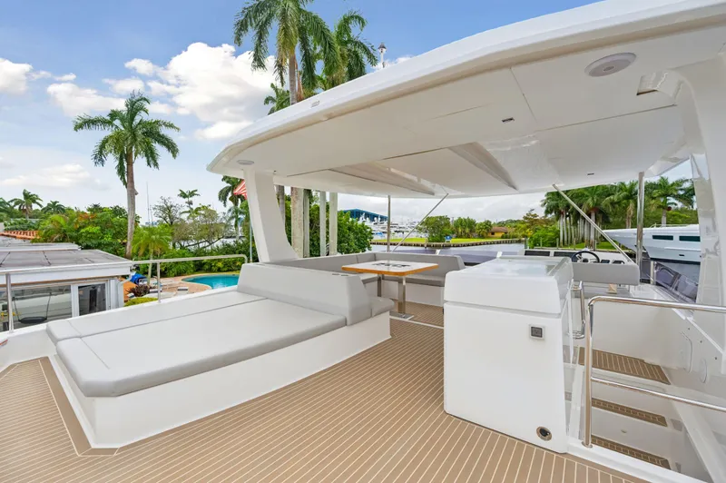 Slide: The Image of 2024 Leopard 53 Powercat yacht deck with seating and tropical backdrop. - 35