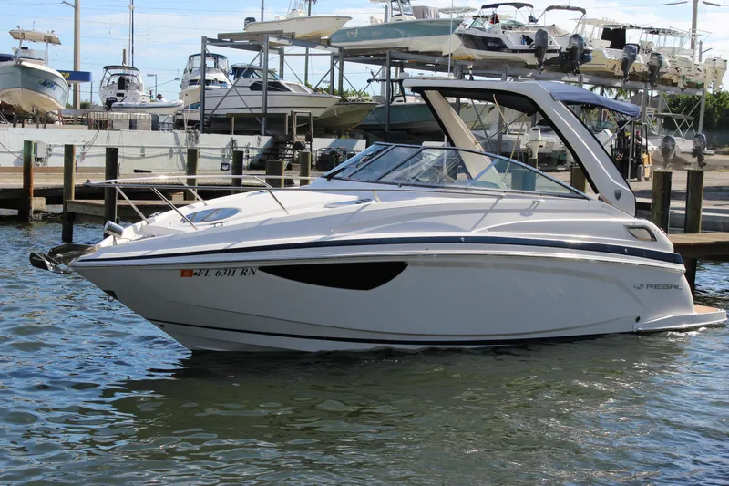 Slide: The Image of 2018 Regal 28 Express boat docked at marina, surrounded by other vessels. - 1