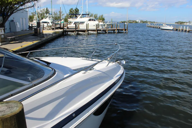 Slide: The Image of 2018 Regal 28 Express boat docked at a marina with clear blue water. - 11