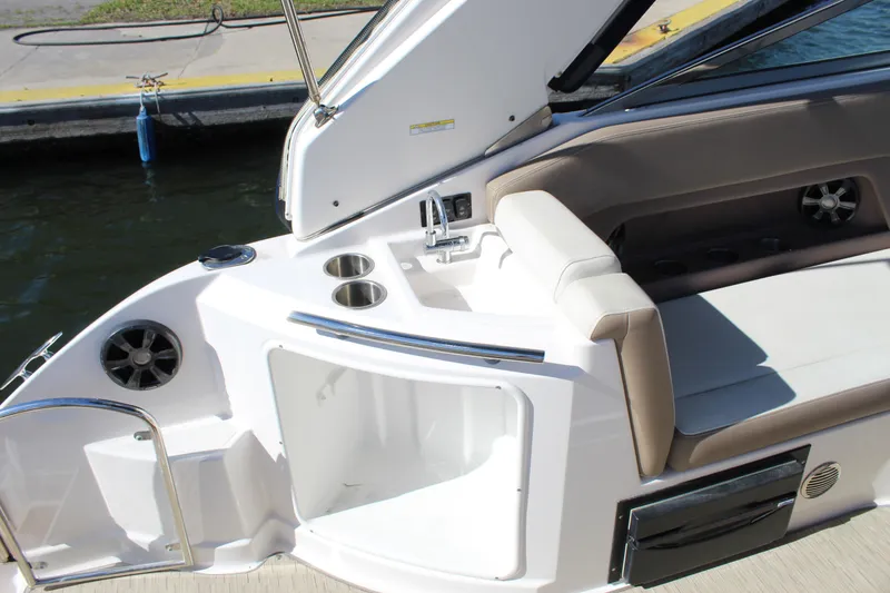 Slide: The Image of 2018 Regal 28 Express boat interior with seating, cup holders, and storage. - 15
