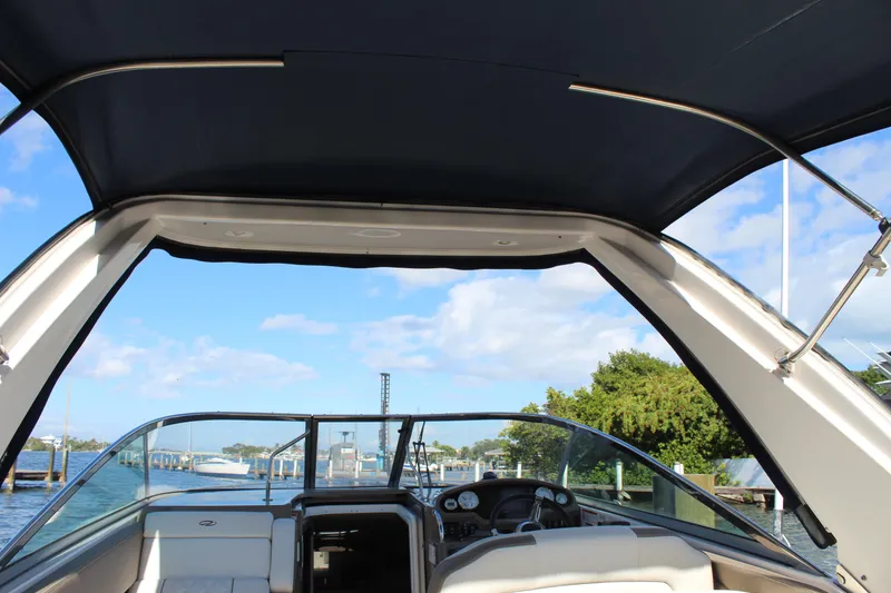 Slide: The Image of 2018 Regal 28 Express boat interior with canopy, docked by a scenic waterfront. - 19