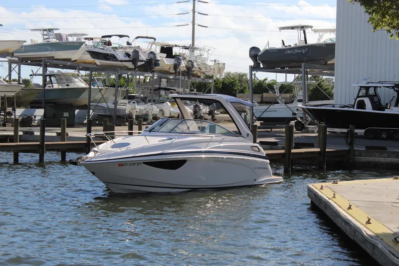 Slide: The Image of 2018 Regal 28 Express boat docked at a marina with other vessels. - 2