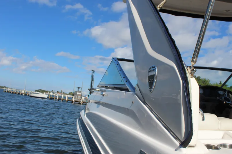 Slide: The Image of 2018 Regal 28 Express boat on water, clear sky, dock in background. - 21