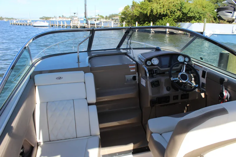 Slide: The Image of 2018 Regal 28 Express boat interior with steering wheel and seating, docked by the water. - 22