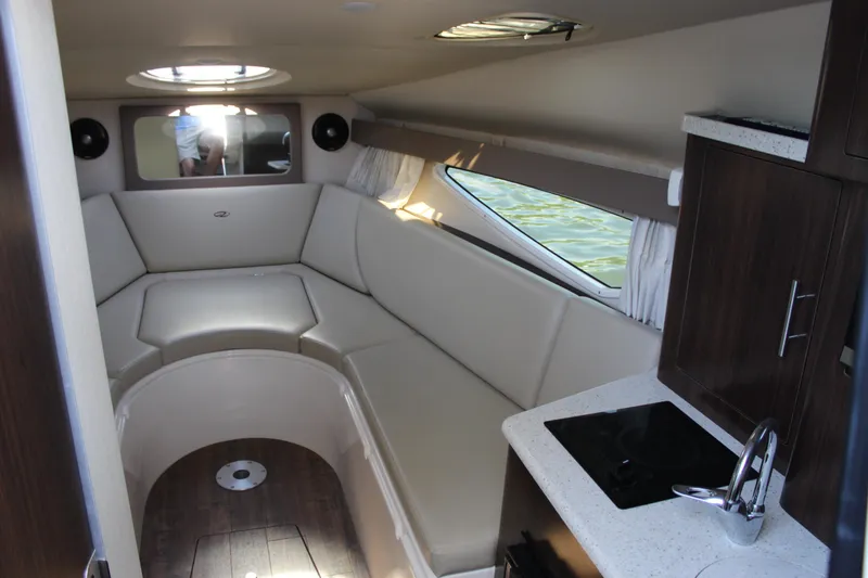 Slide: The Image of 2018 Regal 28 Express cabin interior with seating, kitchenette, and window view. - 28