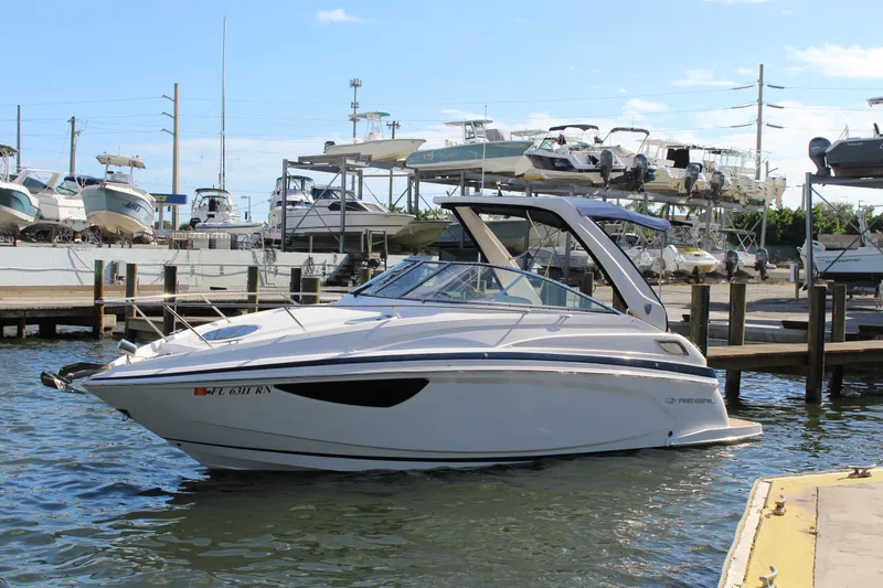 Slide: The Image of 2018 Regal 28 Express boat docked at marina, surrounded by other boats. - 3